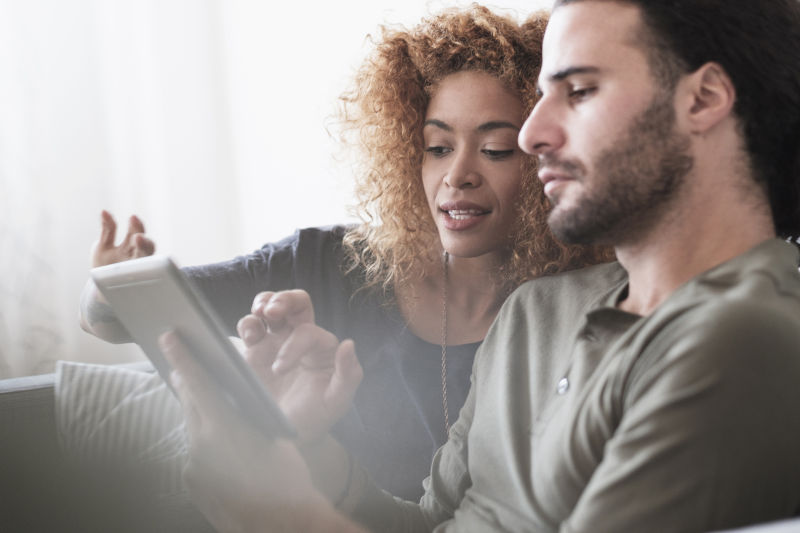 A man and woman looking at a tablet screen